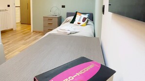 A bedroom with a skylight, a bed with pillows, a bedside table, and a book on the bed. - Candiani Building - Modern 2BR Apartment Steps From Bovisa Politecnico (Milan)