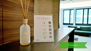 A reception area with a modern design, featuring a wooden wall, a reception desk, a bottle of Culti candles, and a signboard with QR codes. - S Babila Central Tower w Rooftop Terrace in San Babila (Milan)