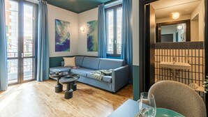 Una sala moderna con un sofá, una mesa de centro y una zona de comedor con sillas.