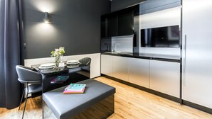 Una cocina moderna con una decoración en blanco y negro, electrodomésticos de acero inoxidable y un comedor con mesa y sillas.