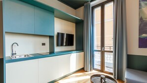 Una cocina moderna con televisor integrado, un lavamanos y un ventanal con cortinas.