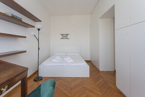 A bedroom with a bed, a desk, a chair, a floor lamp, and a wardrobe. - Biancamano Skyline View - 13th Floor 1 bdr With Balcony in Moscova Sempione (Milan)