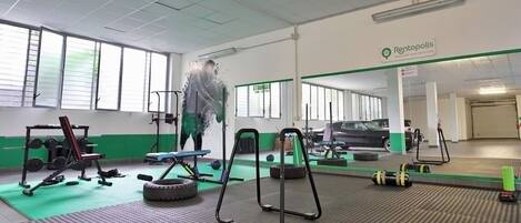 A gym with exercise equipment, a mirror, and a sign for Rentopolis.
