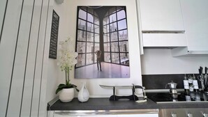 A modern kitchen with a large window, a potted orchid, and a knife block on the counter. - Candiani D3 Bilocale 2 Livelli (Milan)
