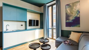 Una sala moderna con un sofá gris, una mesa de centro y un televisor montado en la pared.