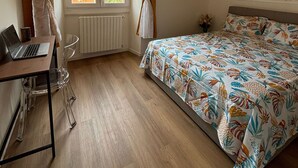 A bedroom with a bed, a desk with a laptop, a chair, and a window with curtains. - Venini - Cozy 2 Bdroom Apartment in Loreto Area (Milan)
