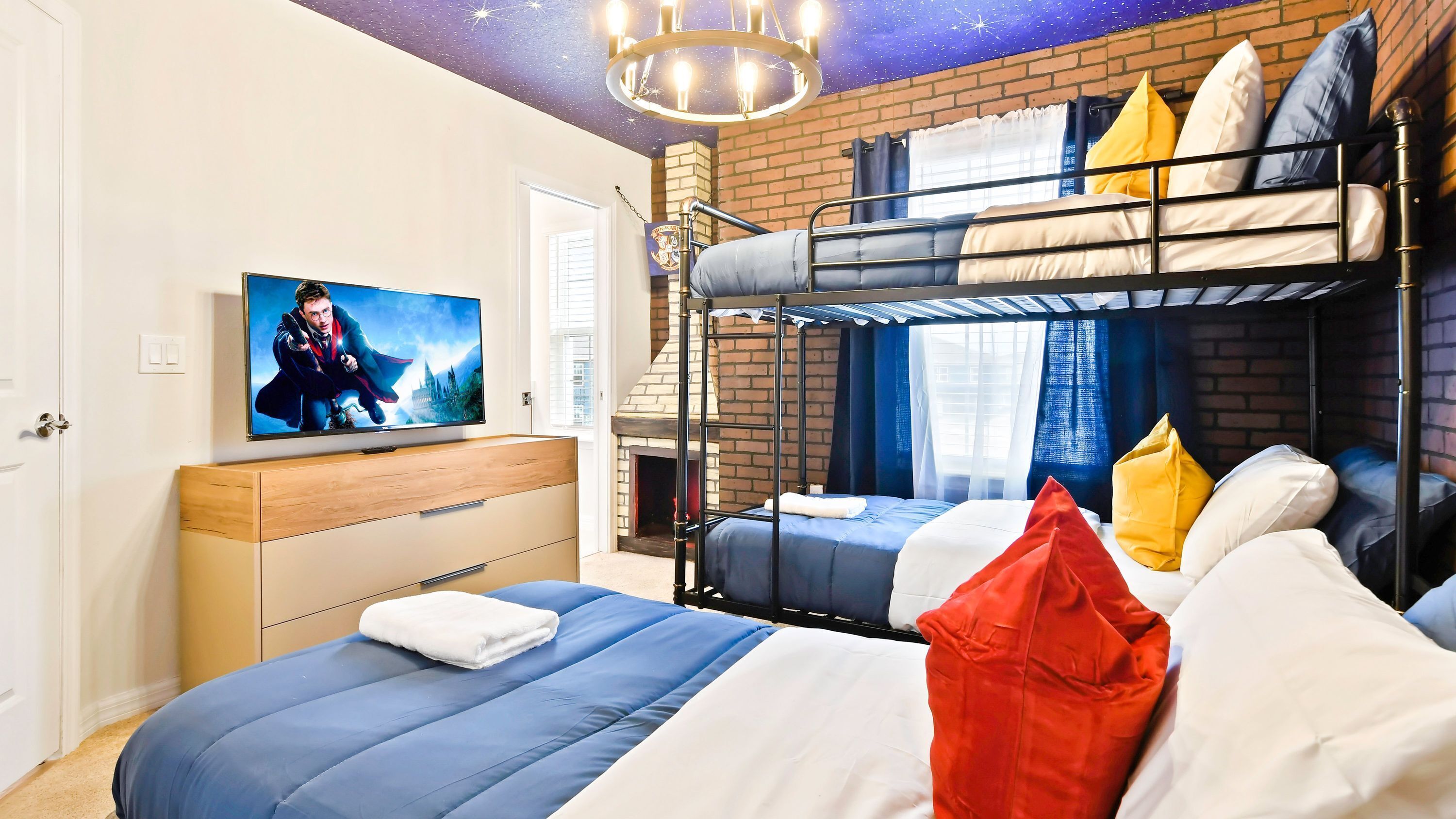 Una habitación con literas, televisión de pantalla plana, chimenea y un techo que simula un cielo estrellado.