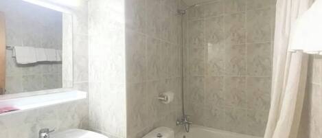 A bathroom with a sink, toilet, and shower.
