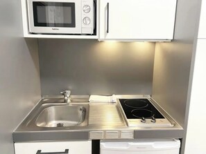 Microondas, placa de cocina y utensilios de cocina
