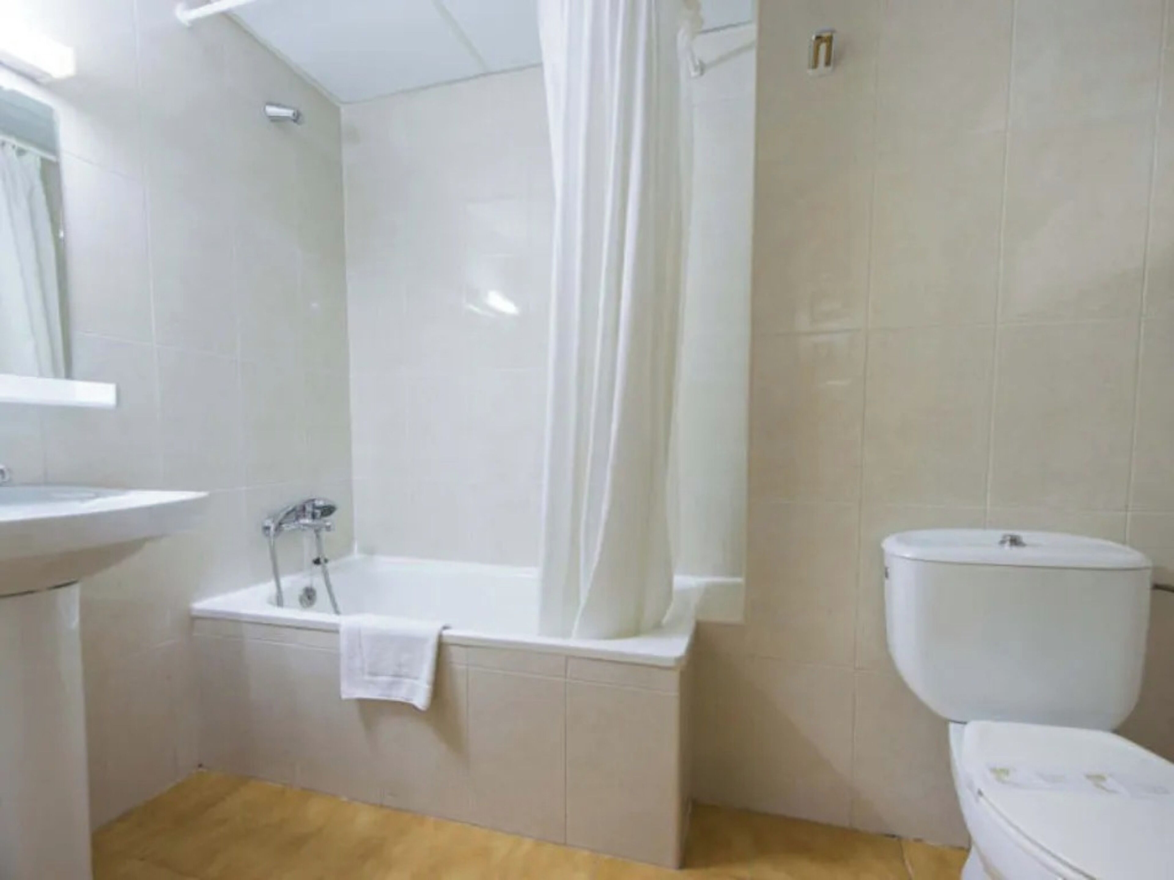 A bathroom with a bathtub, toilet, and sink.