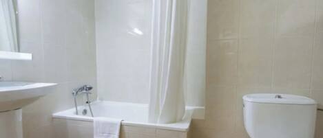 A bathroom with a bathtub, toilet, and sink.