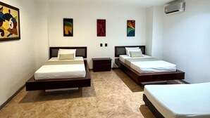A hotel room with three beds, a tiled floor, and artwork on the walls. - Hotel Plaza Mayor 44 - Medellin (Medellín)