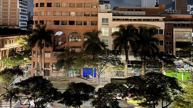 Un edificio de varios pisos con fachada de ladrillo, ventanas grandes y techo plano.