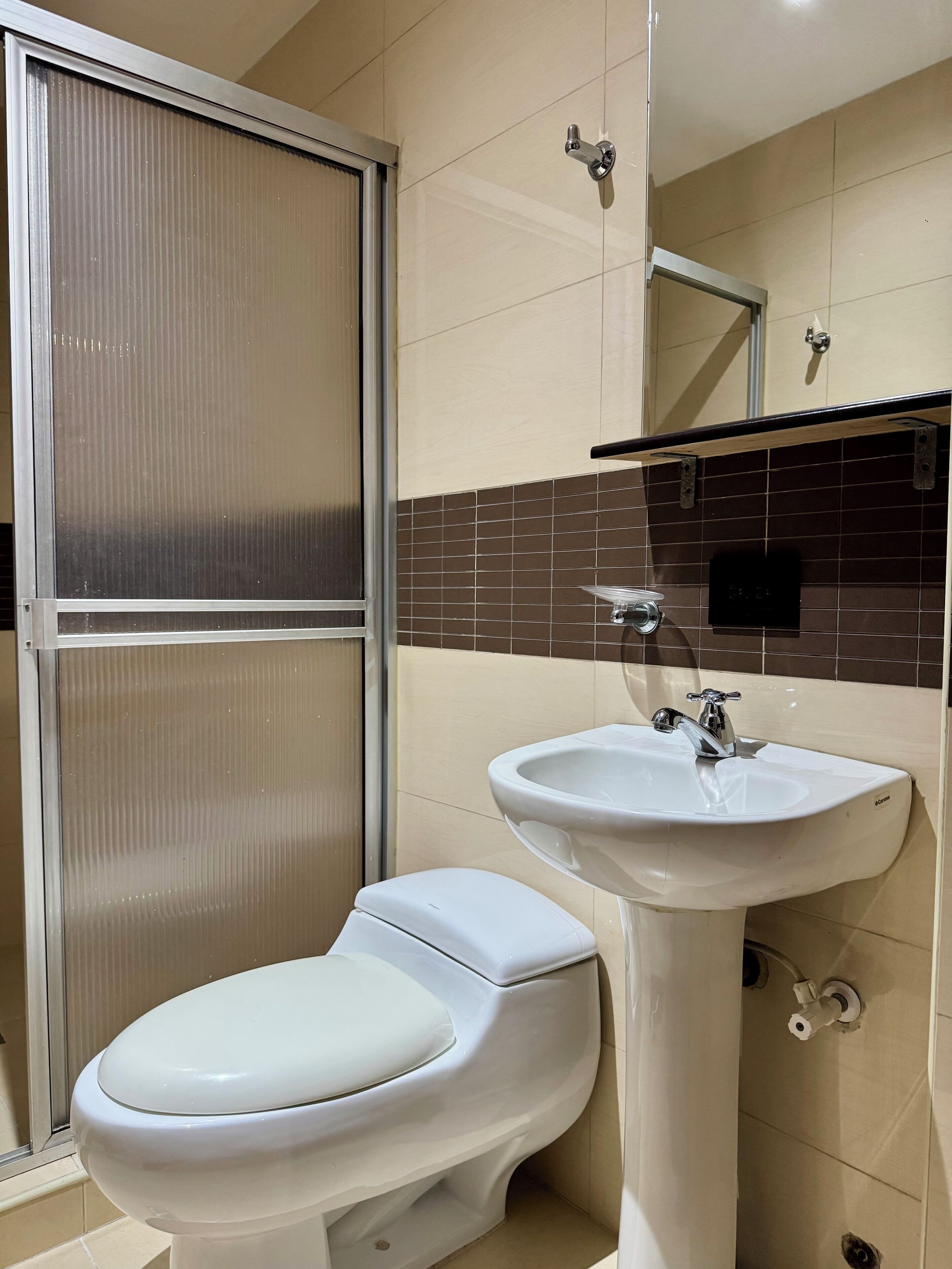Un baño con inodoro, lavabo y zona de ducha.