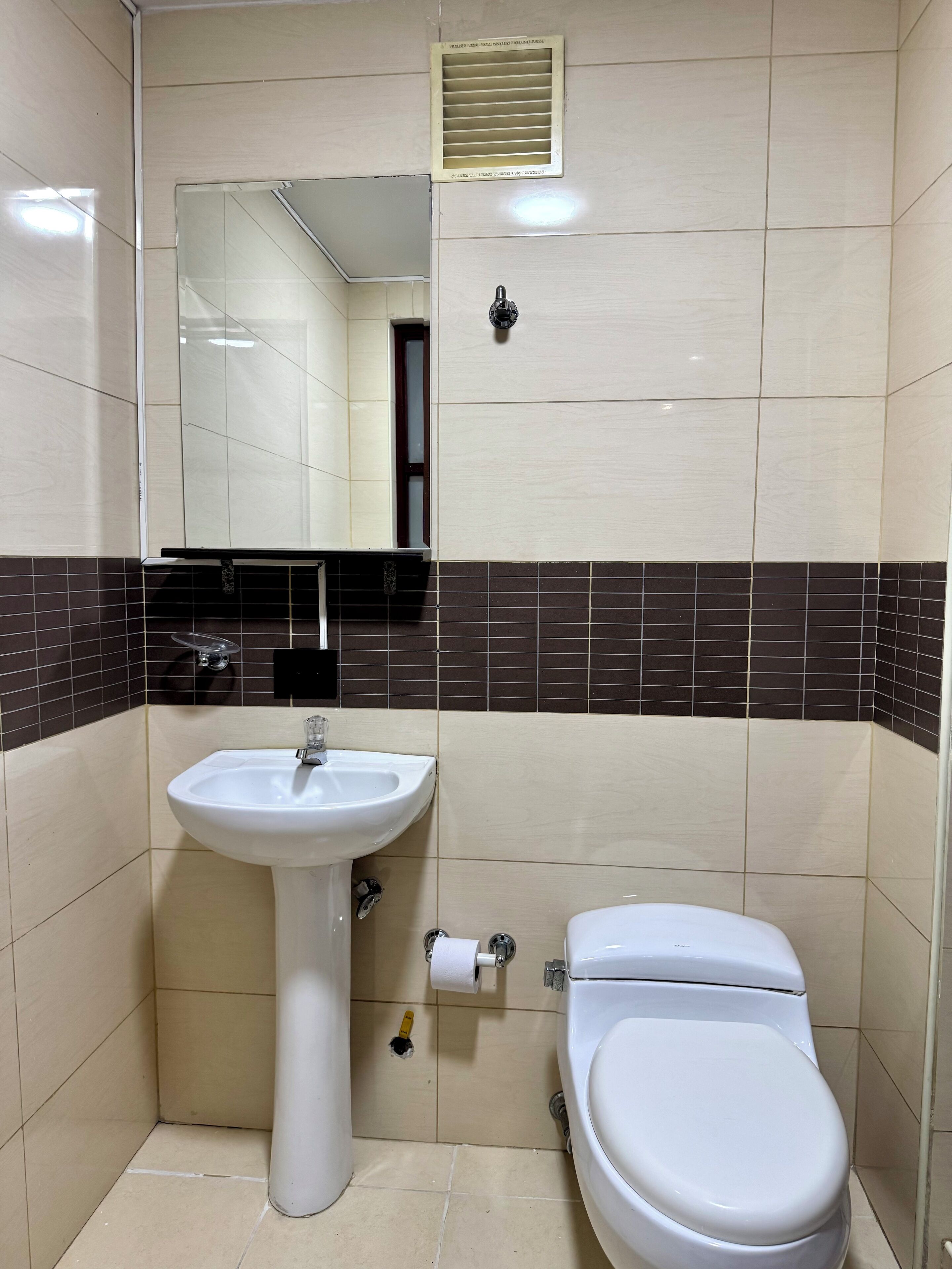 A bathroom with a white sink, a toilet, and a mirror.
