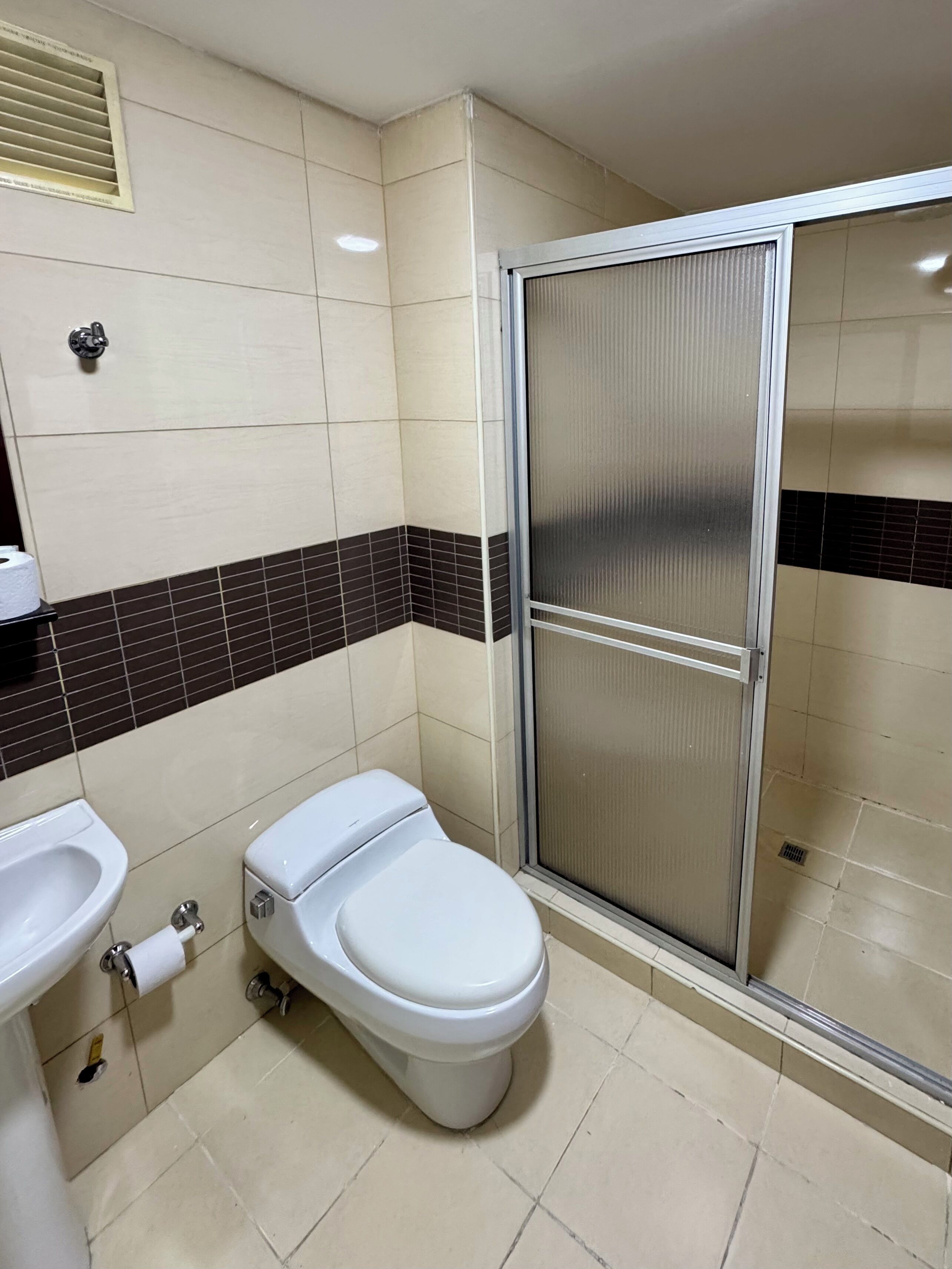 A bathroom with a toilet, bidet, and a shower stall.