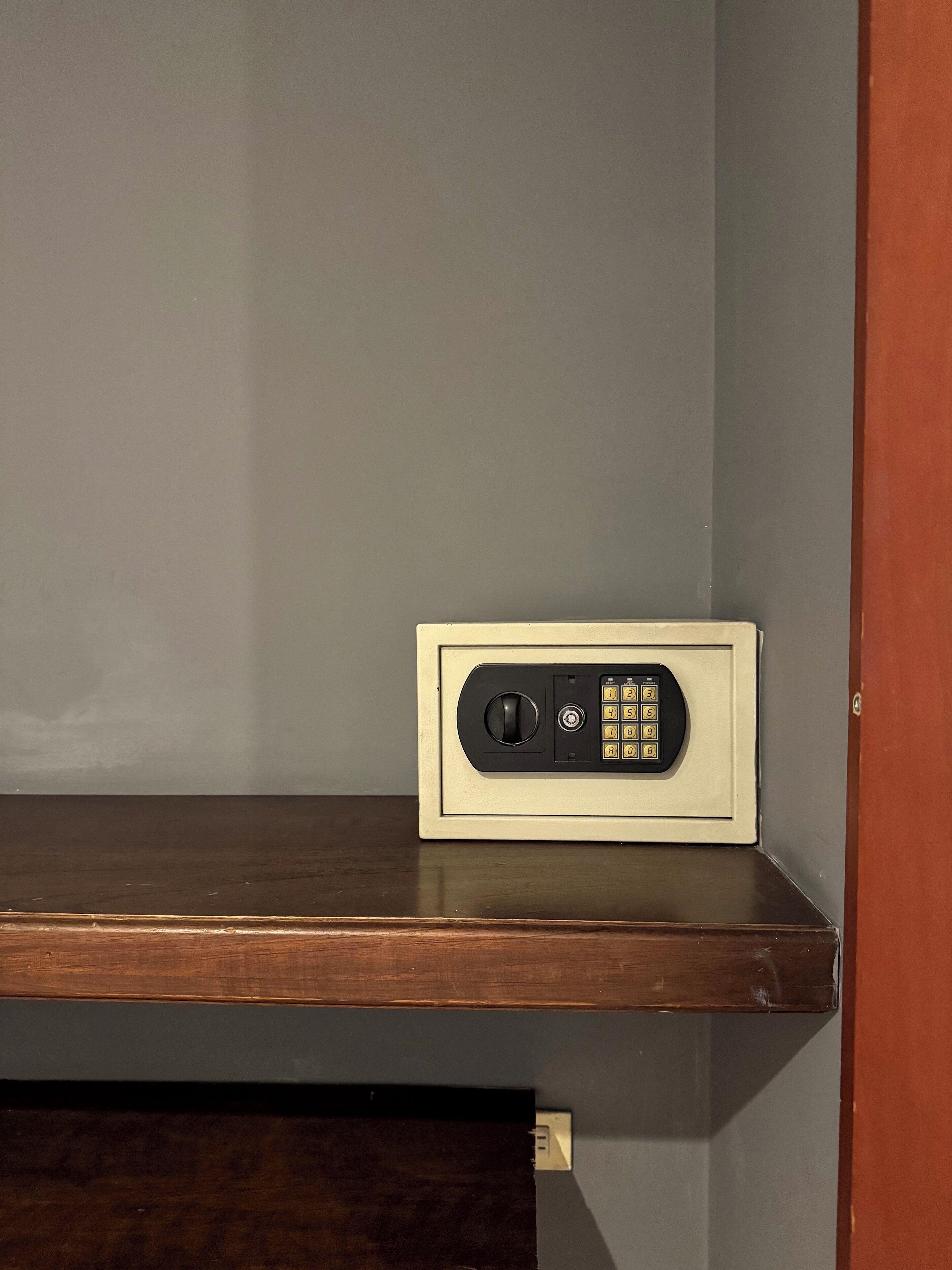 A security keypad on a wooden shelf.