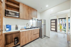 A modern kitchen with wooden cabinets, a stainless steel refrigerator, a microwave, and a gas stove. - New Sea La Vie Suite # 2 |2BR|1BR W. Pool&Jacuzzi (Noord)