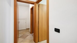 Un pasillo con puertas de madera y un interruptor de luz en la pared.