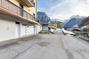 A street with buildings, a bridge, and mountains in the background.