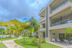 A modern hotel with a pool, outdoor seating, and lush greenery. - Tracadero Lodge Con Acceso al Beach Club (Dominicus)
