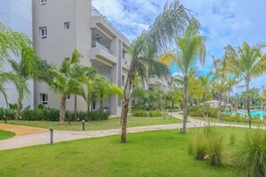 A modern hotel with a pool, palm trees, and a clear sky. - Tracadero Lodge Con Acceso al Beach Club (Dominicus)
