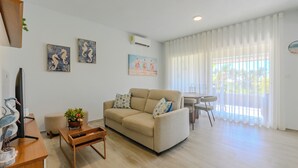 A living room with a sofa, a coffee table, a TV, and artwork on the walls. - Tracadero Lodge Con Acceso al Beach Club (Dominicus)