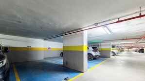 A multi-level parking garage with clearly marked parking spaces and directional arrows on the floor. - Your Dream Vacation (Marbella)