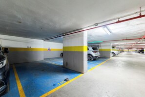 Un parking à plusieurs niveaux, doté d’emplacements clairement délimités et de flèches directionnelles peintes sur le sol.