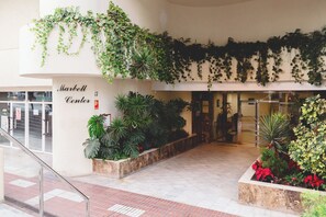 Une entrée d'immeuble avec une enseigne indiquant « Marbell Center » et un escalier menant à l'étage.