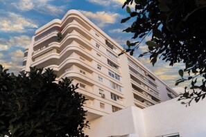 A multi-story building with balconies and windows, surrounded by greenery. - Your Dream Vacation (Marbella)