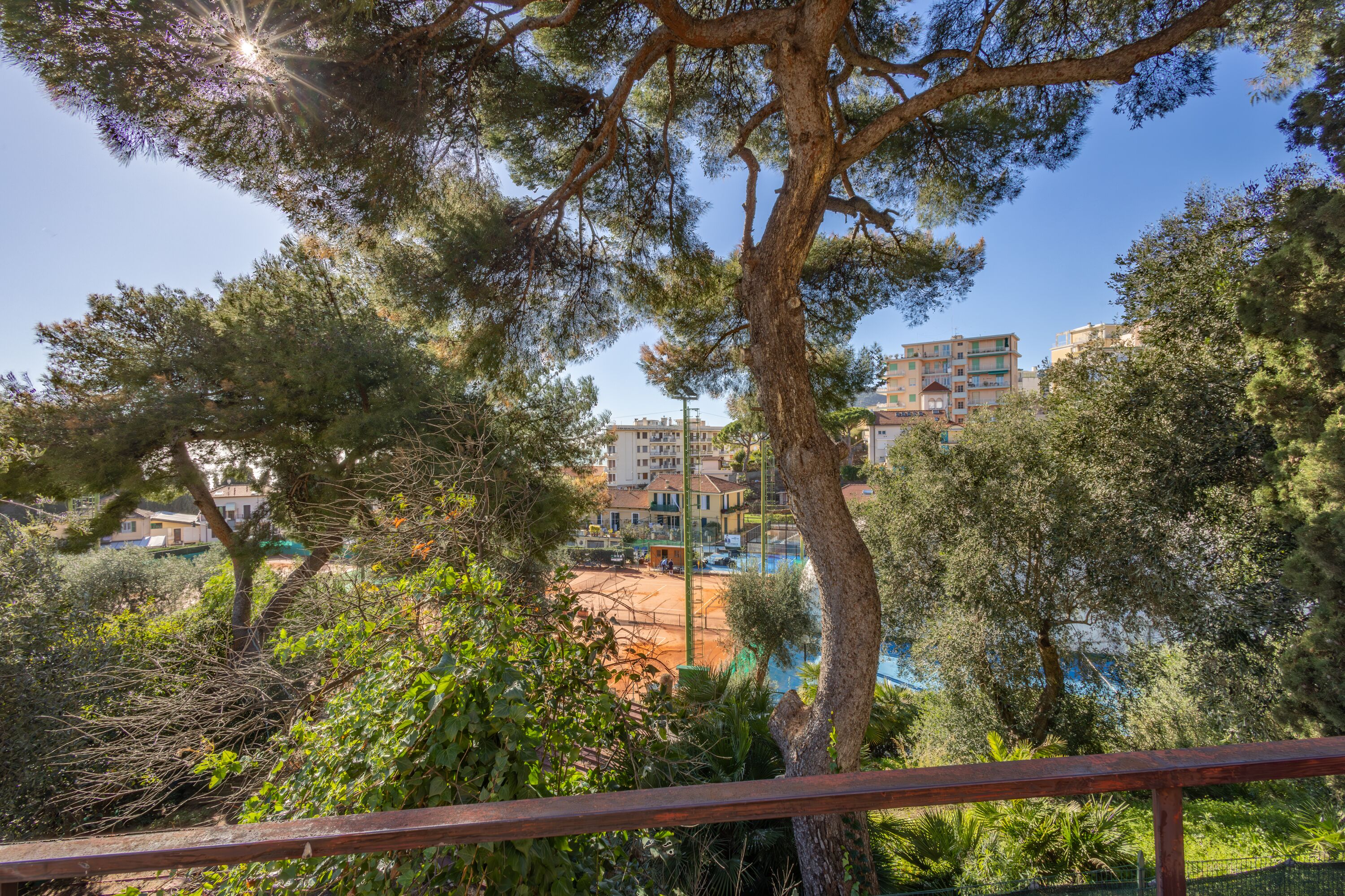 A view of a residential area with multiple apartment buildings, surrounded by trees and greenery.