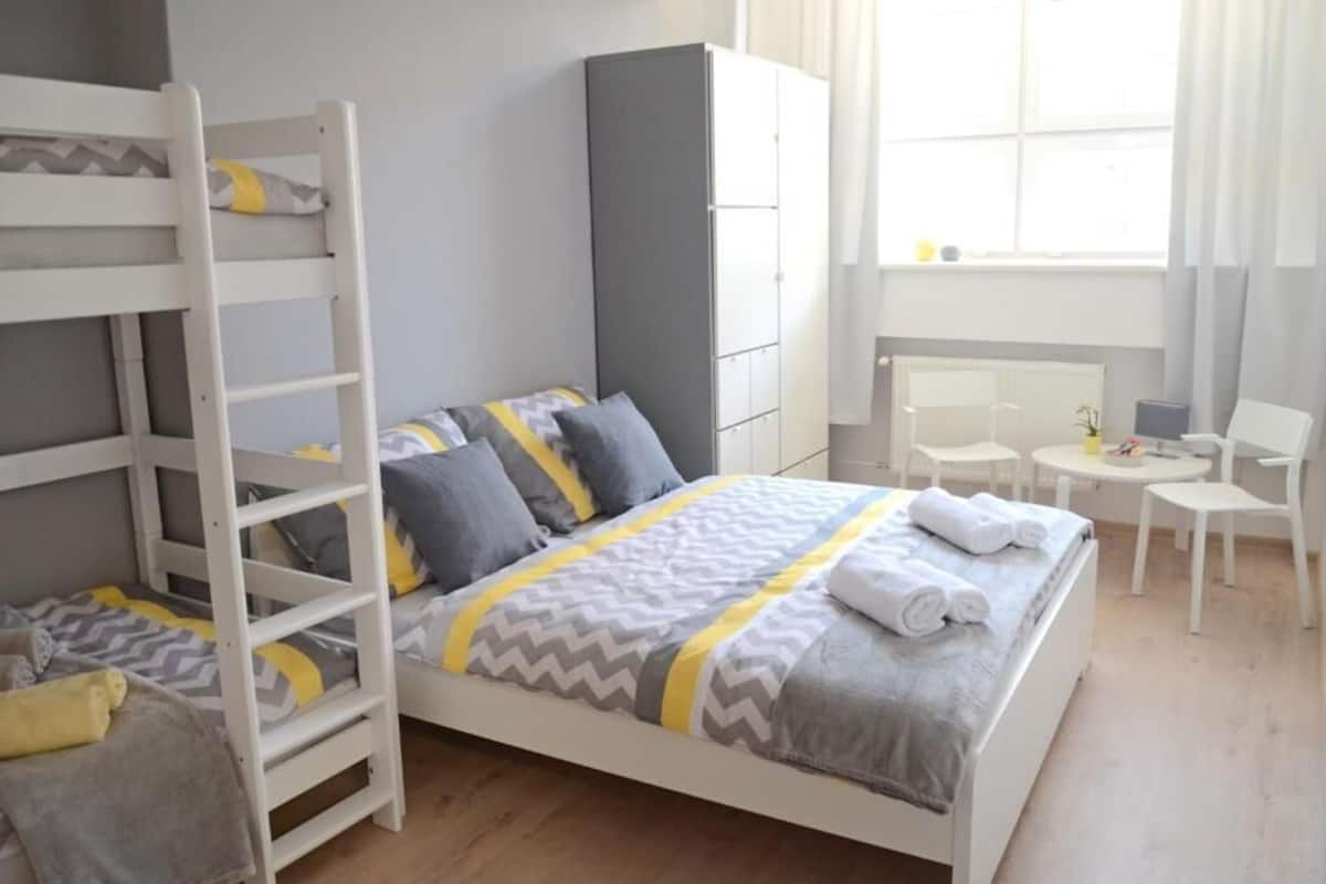 A bedroom with bunk beds, a desk, and a chair.