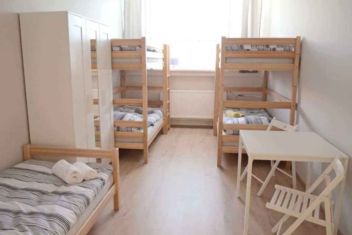 A room with bunk beds, a desk, and a wardrobe.