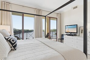 A bedroom with a large bed, a TV, and a balcony with a view of the sea. - Gulf-Front Luxury | Family Friendly | 3-Bedroom Escape (Santa Rosa Beach)
