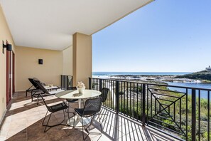 A balcony with a table and chairs, a view of the beach, and a railing. - Gulf-Front Luxury | Family Friendly | 3-Bedroom Escape (Santa Rosa Beach)