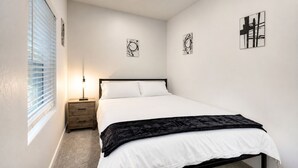 A bedroom with a bed, bedside table, lamp, and artwork on the walls. - Scottsdalestays Multimillion Estate on Huge Acre Lot-Pool-Slide-Sports Courts (Scottsdale)