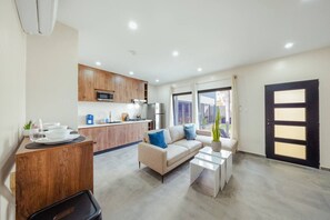 A modern apartment with a kitchen, a living area with a sofa and coffee table, and a large window. - New Sea La Vie Suite # 3 |2BR|1BR W. Pool&Jacuzzi (Noord)