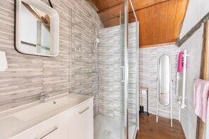 A modern bathroom with a glass shower enclosure, a white sink, and a mirror. - Holiday Home “La Maison Blanche” with Private Terrace and Wi-Fi (Nazelles-Négron)