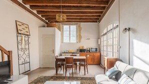 Un espace de vie compact comprenant un coin repas, une kitchenette et un canapé.