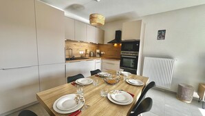 Een moderne keuken met een houten eettafel, compleet met borden, glazen en bestek.