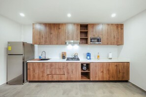 A modern kitchen with wooden cabinets, a stainless steel refrigerator, a microwave, and a gas stove. - New Sea La Vie Suite # 5 |2BR|1BR W. Pool&Jacuzzi (Noord)
