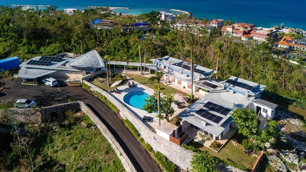 Une propriété située sur la côte, dotée d’une piscine, de panneaux solaires et offrant une vue sur la mer.