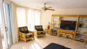A living room with two armchairs, a sofa, a TV, and a ceiling fan. - Beachfront Perdido Key Condo | Private Balcony (Pensacola)