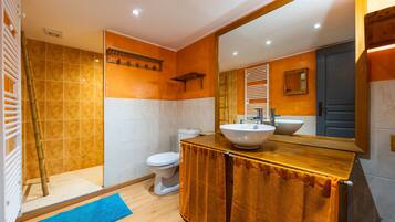 Een badkamer met een grote spiegel, een wastafel en een toilet.