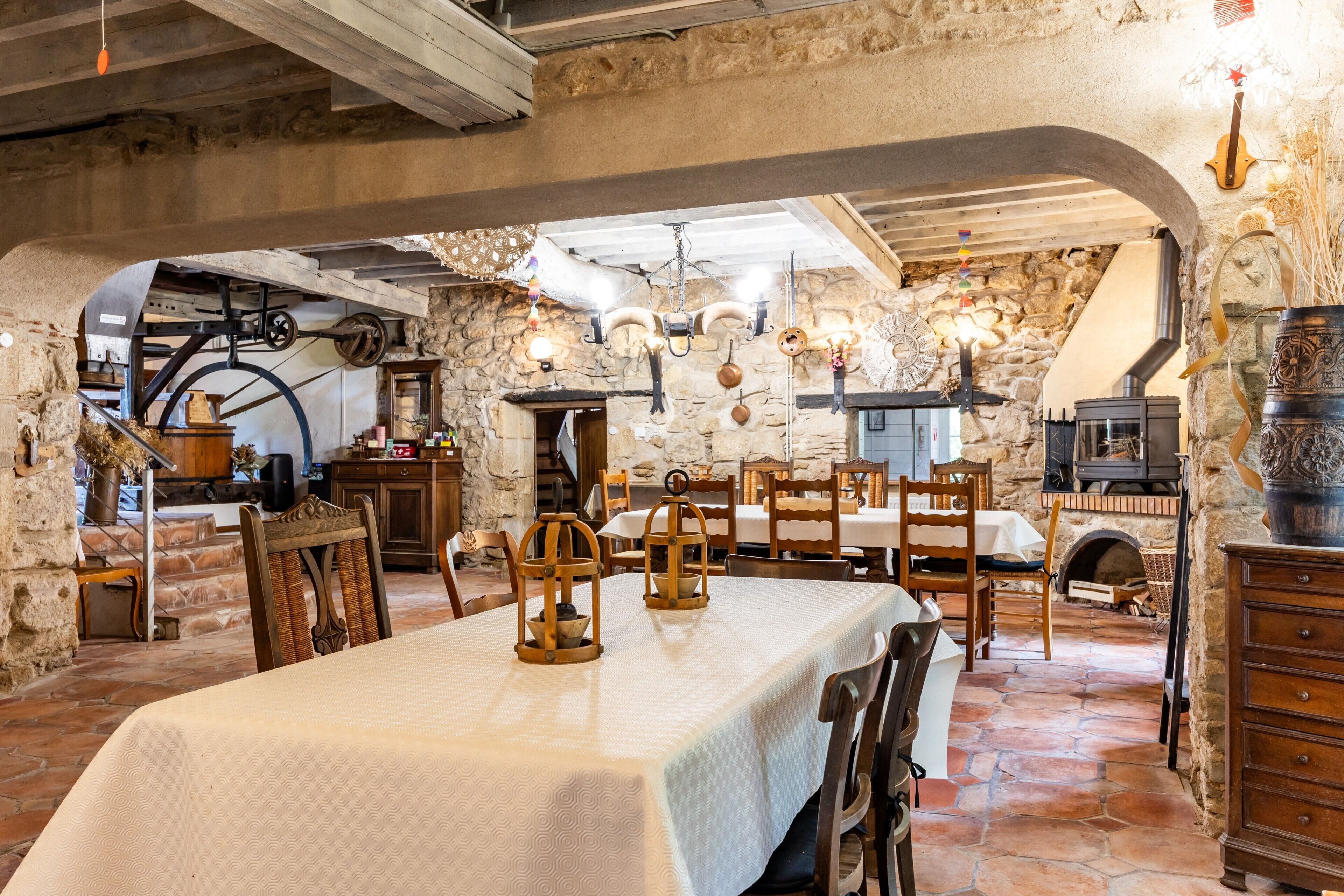Un'area pranzo rustica con pareti in pietra, arredi in legno e un camino.