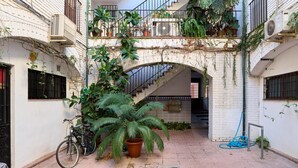 Un patio con escaleras, plantas en macetas y una bicicleta.