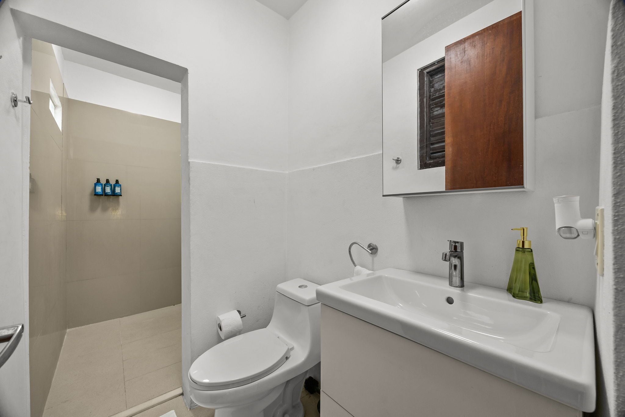 A bathroom with a toilet, sink, and shower area.