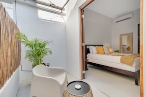 Un dormitorio moderno con cama, mesita de noche y una planta en maceta.