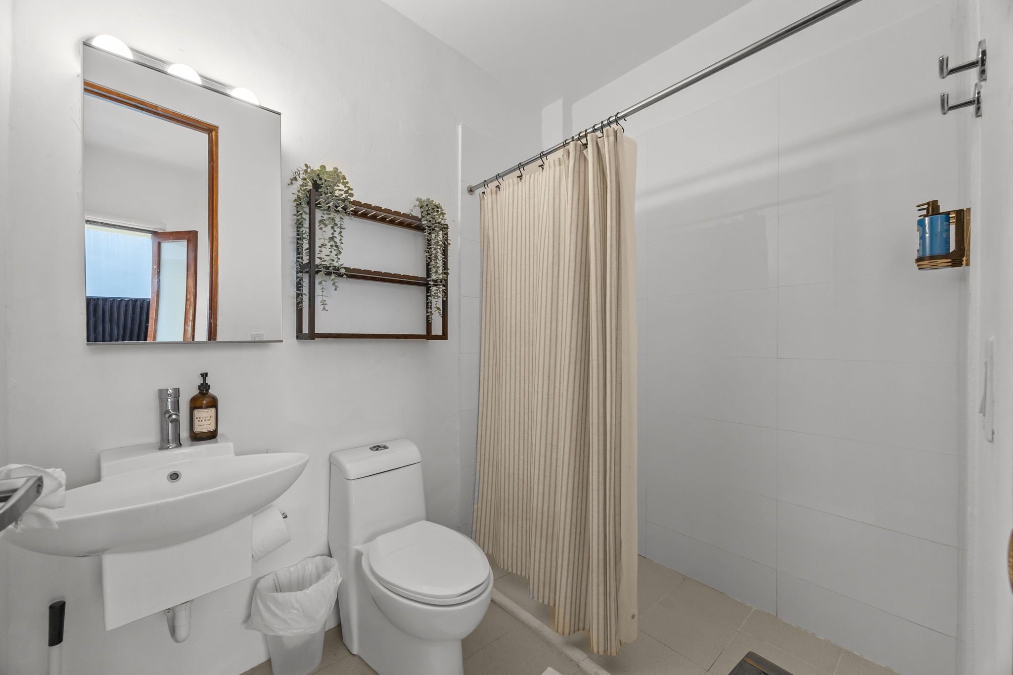 Ein modernes Badezimmer mit Waschbecken, Toilette und Duschvorhang.
